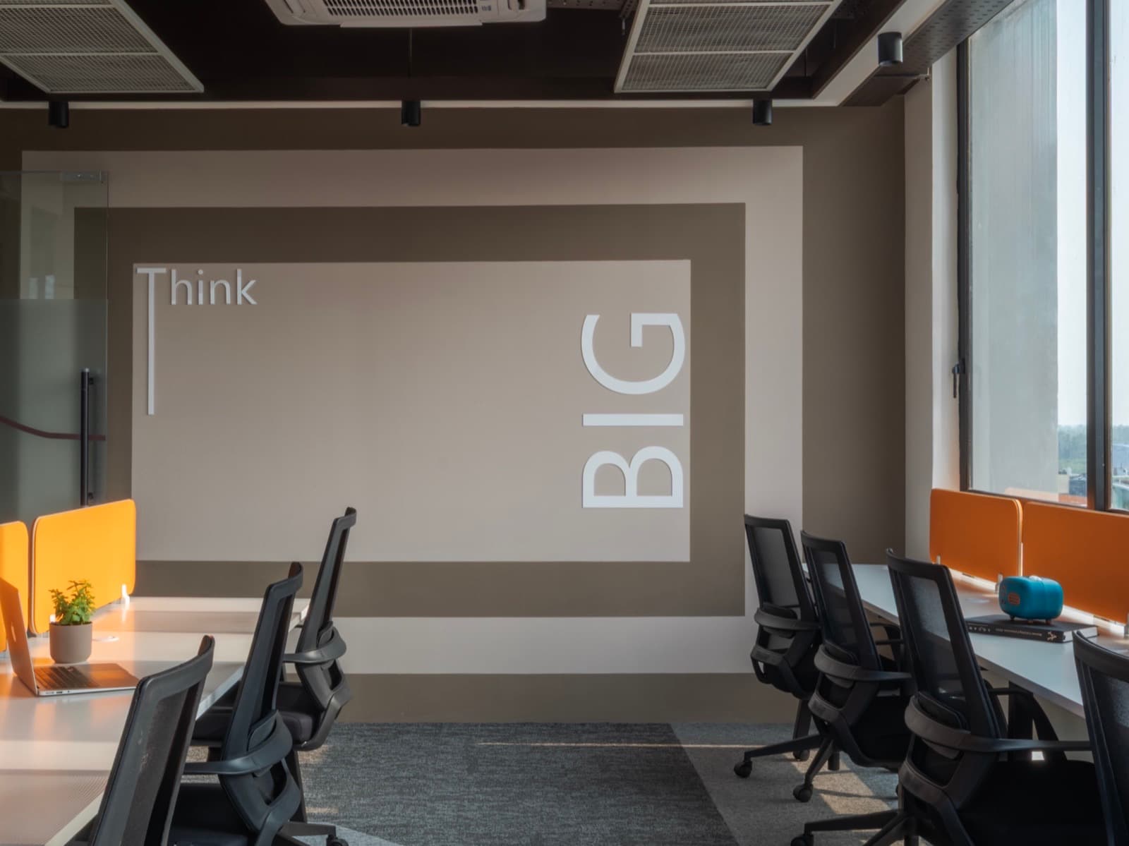 Think Big feature wall between the twin desk rows of the 16 seater lake view office at Fliqzo