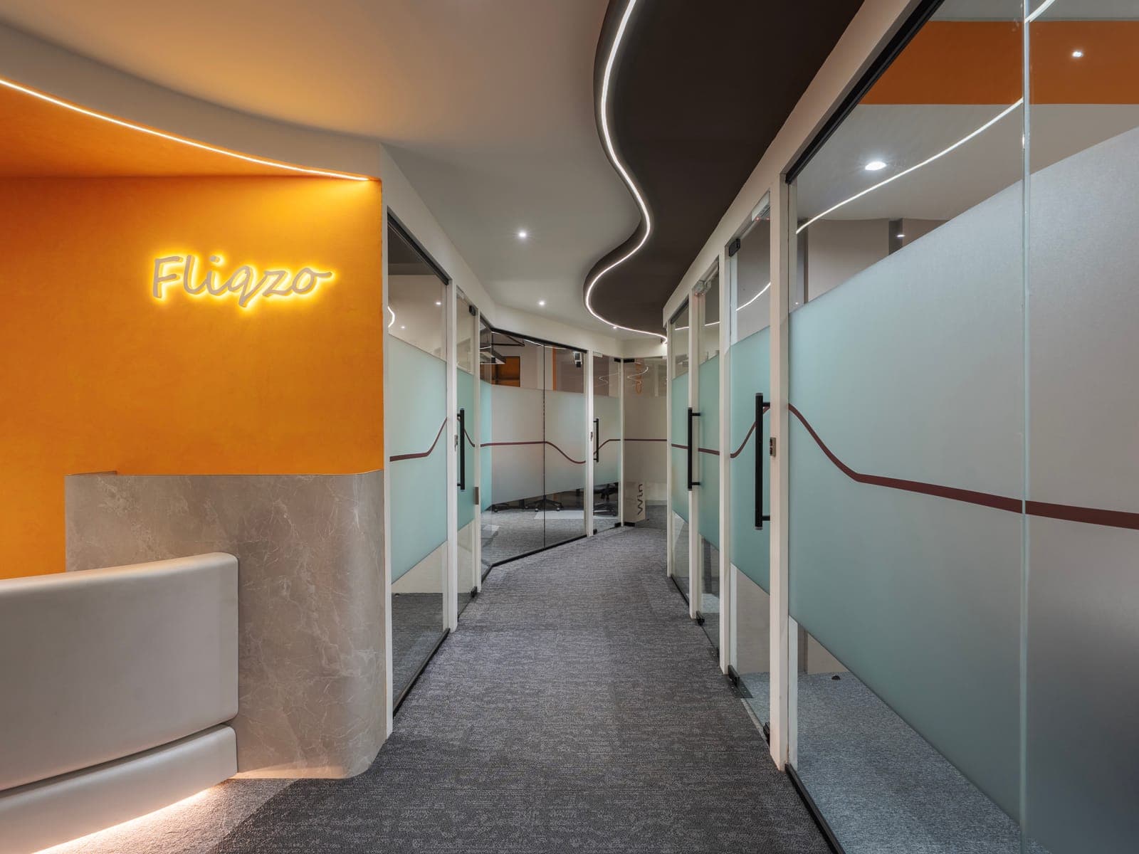 Corridor with backlit Fliqzo sign leading to the 4 seater private office at Fliqzo Coimbatore