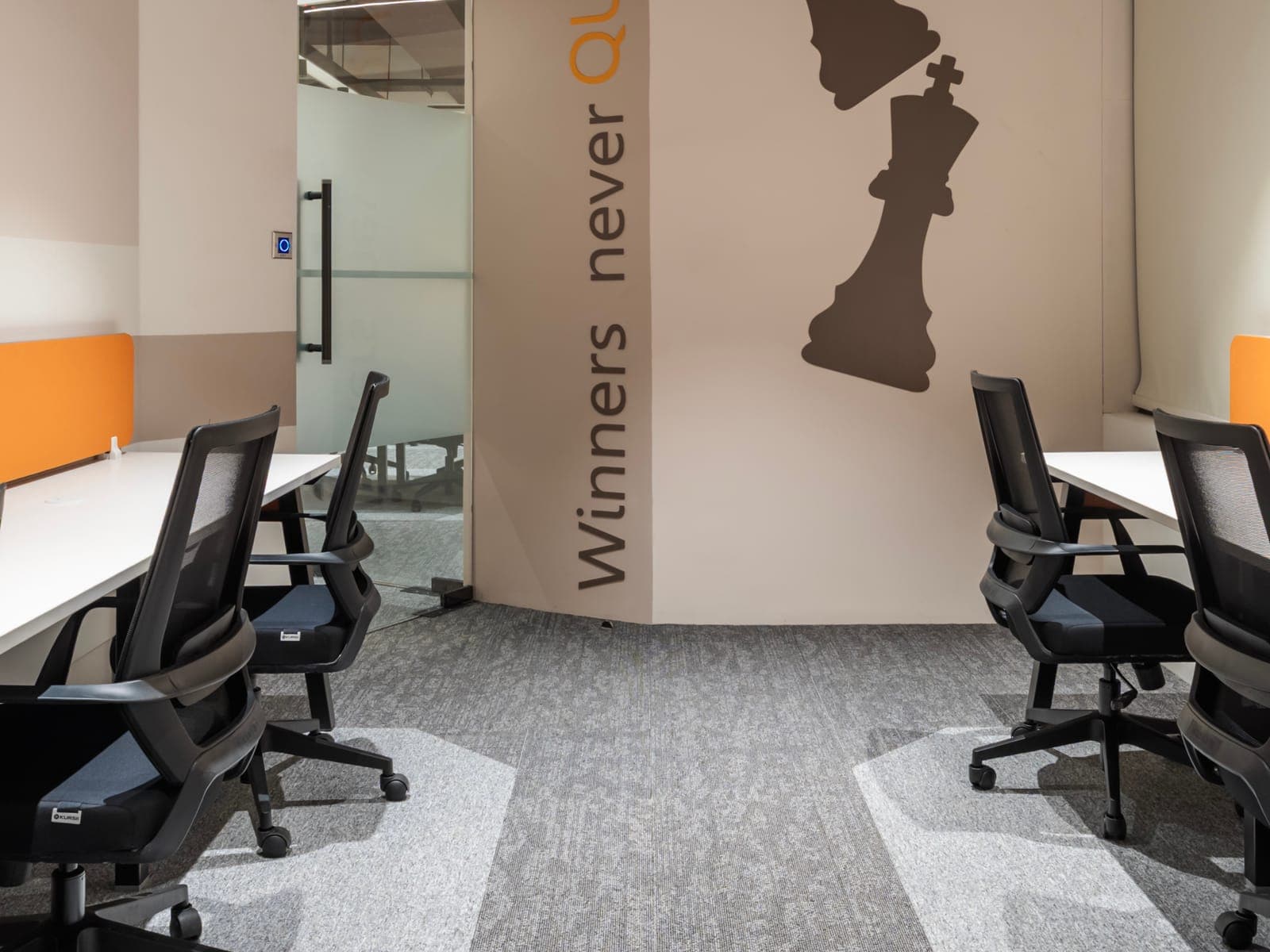 Winners Never Quit chess mural and glass door between the facing desk rows of the 8 seater office at Fliqzo