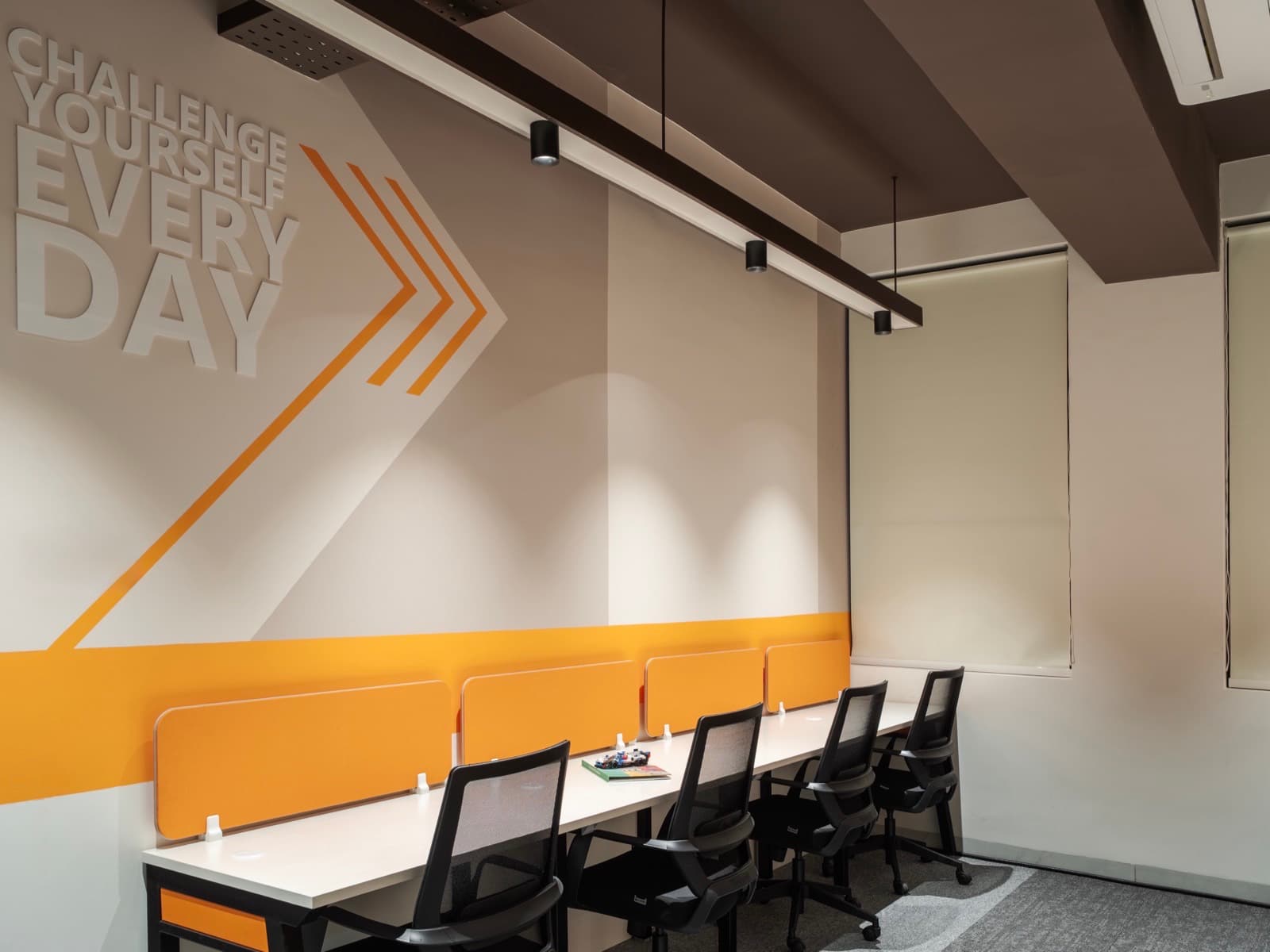 Challenge Yourself Every Day mural above the window-side desk row in the 8 seater lake view office at Fliqzo